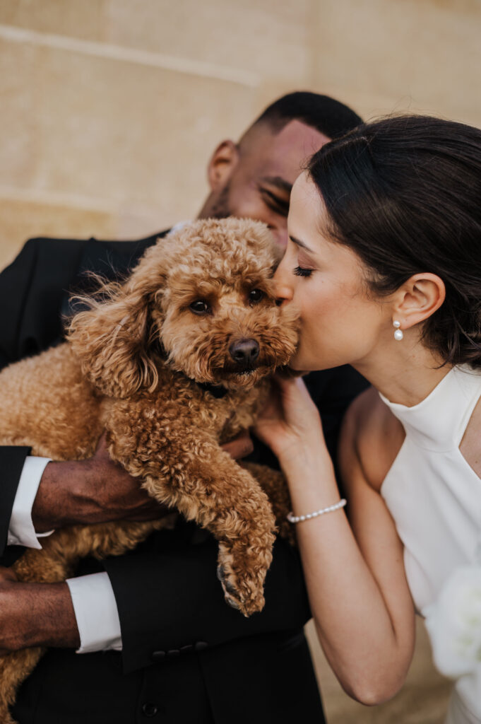 Bride kissing her dog at a wedding